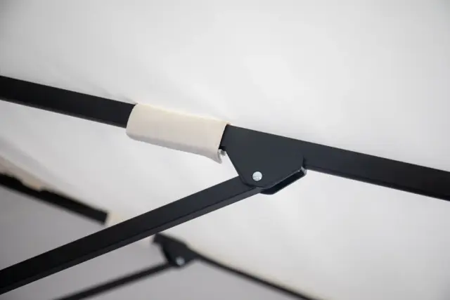 A detailed shot of the robust, black powder-coated aluminum frame joint on the Istanbul center pole umbrella, highlighting the reinforced canopy pocket on the rib.