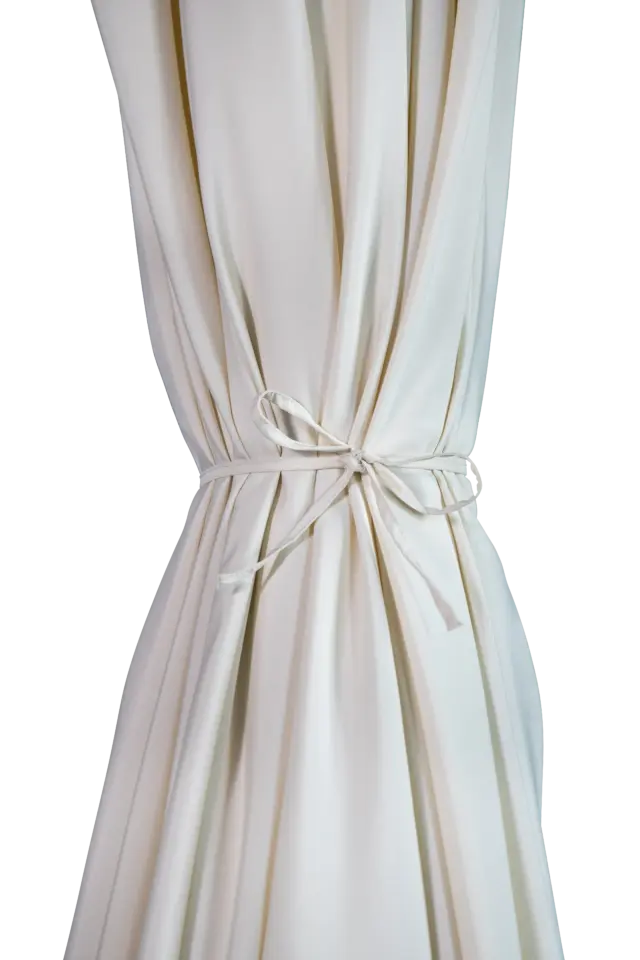 A close-up of the closed white canopy on the Istanbul patio umbrella, neatly secured with its integrated, matching fabric tie strap.